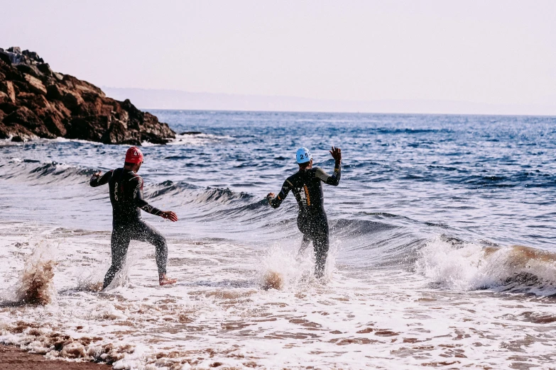 a couple of people that are standing in the water, by Lee Loughridge, pexels contest winner, happening, ironman, coastal, thumbnail, swimming