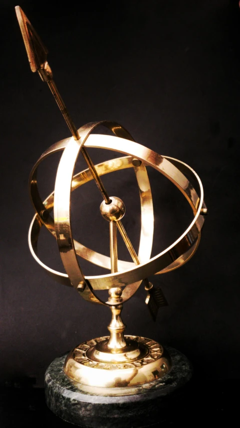 a close up of a metal object on a table, by Thomas Furlong, unsplash, kinetic art, astrolabe, gold plated, globes, ilustration