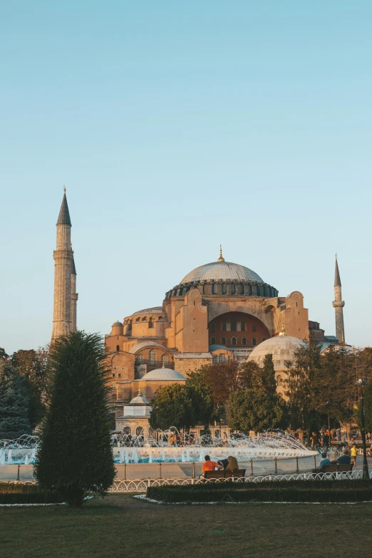 a large building sitting on top of a lush green field, hurufiyya, with great domes and arches, during golden hour, 🚿🗝📝, 4k photo”