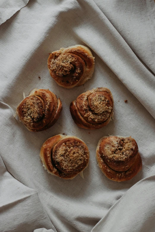 a group of pastries sitting on top of a white cloth, 6 pack, swedish, cinnamon, highly upvoted