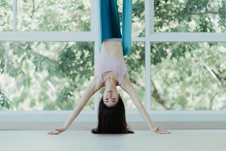 a woman doing a handstand in front of a window, unsplash, arabesque, brunette fairy woman stretching, south east asian with long, avatar image, aerial silk