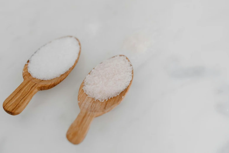 two wooden spoons filled with white sugar, a portrait, trending on pexels, background image, hammershøi, bottom angle, salmon