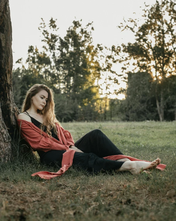 a woman sitting under a tree in a field, inspired by Camille Corot, pexels contest winner, renaissance, black and terracotta, sleepy, casual pose, wearing a velvet robe