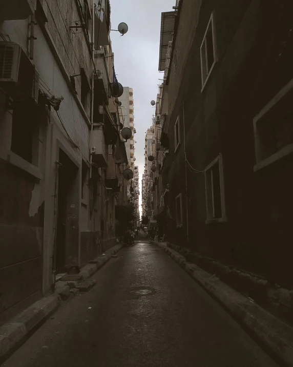 a black and white photo of a narrow street, an album cover, by Ahmed Yacoubi, unsplash contest winner, faded colors, trending on vsco, damascus, taken at golden hour