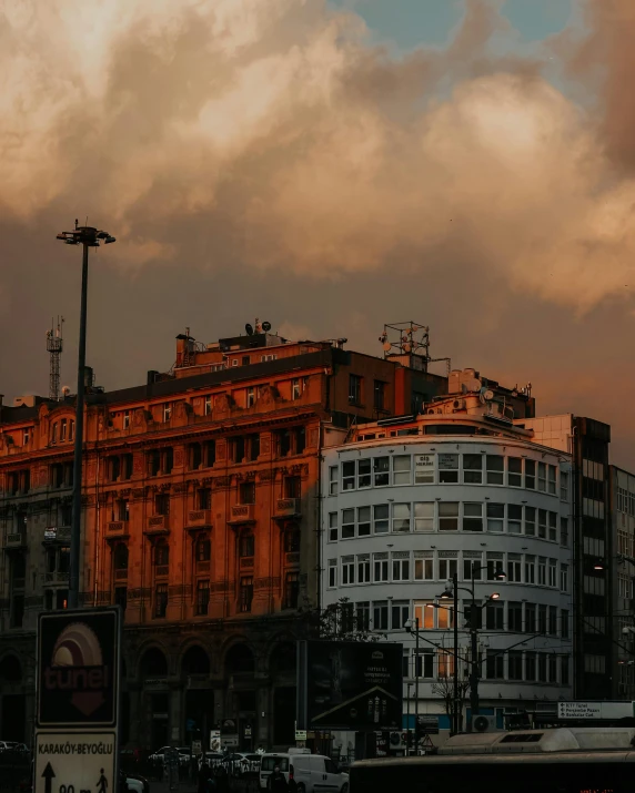 a bus driving down a street next to tall buildings, by Tamas Galambos, unsplash contest winner, neoclassicism, grey skies with two rainbows, sunset panorama, old building, istanbul