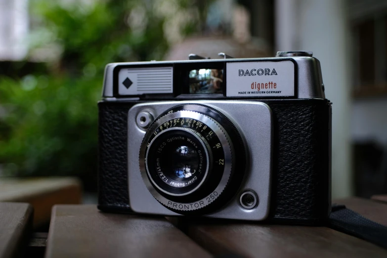 a camera sitting on top of a wooden table, inspired by Elsa Bleda, unsplash contest winner, photorealism, cinematic diane arbus, color photograph portrait 4k, medium format, delightful