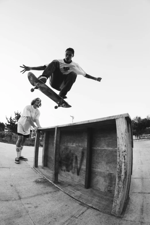 a man flying through the air while riding a skateboard, a black and white photo, neil blevins and jordan grimmer, jemal shabazz, bench, looking this way