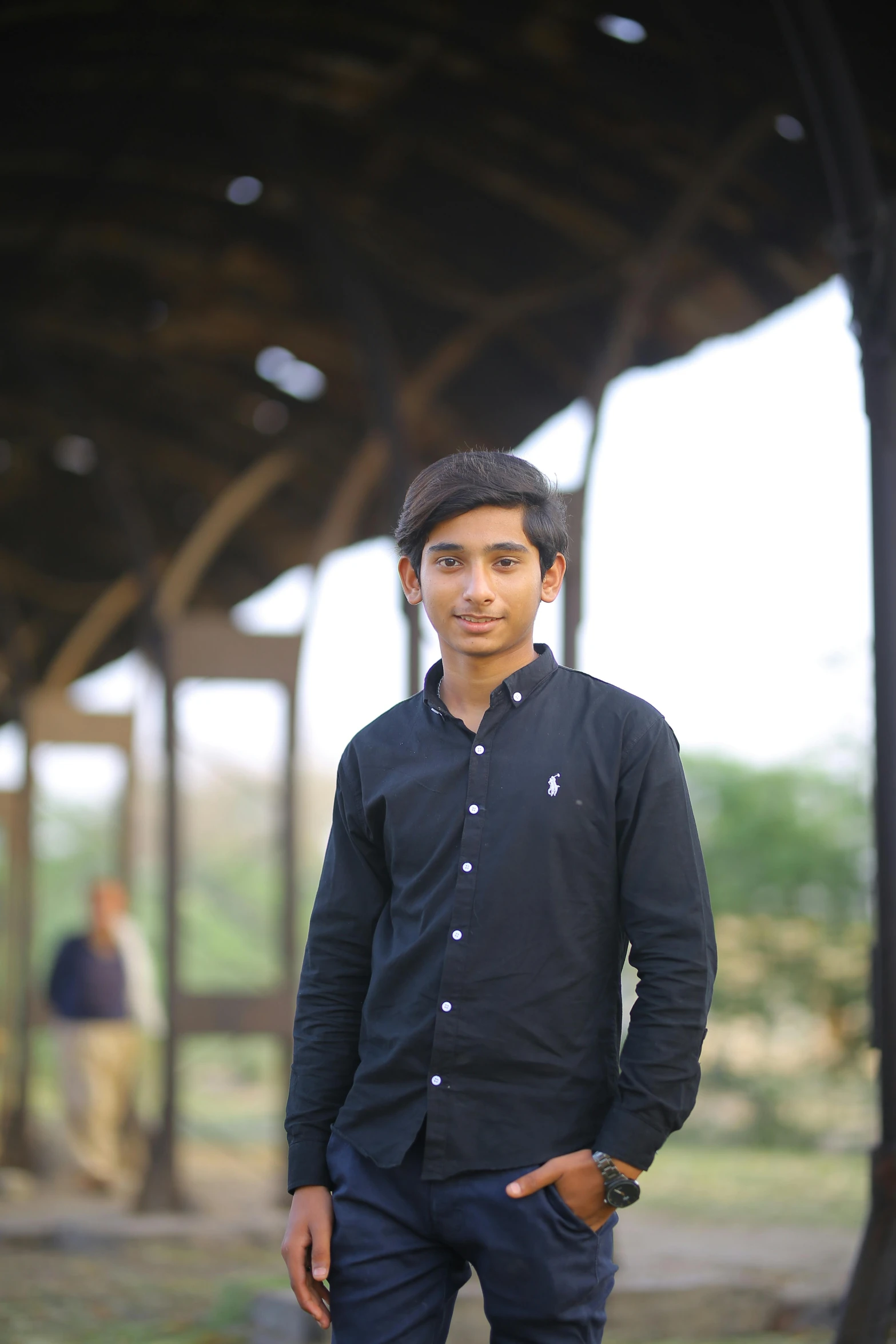 a man standing with his hands in his pockets, a picture, by Byron Galvez, wearing a dark shirt and jeans, raden saleh, young man, college