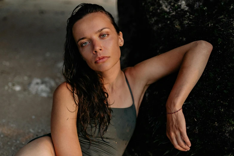 a beautiful young woman sitting on top of a rock, a portrait, by Emma Andijewska, pexels contest winner, renaissance, sweaty wet skin, cute girl wearing tank suit, rugged face, profile image