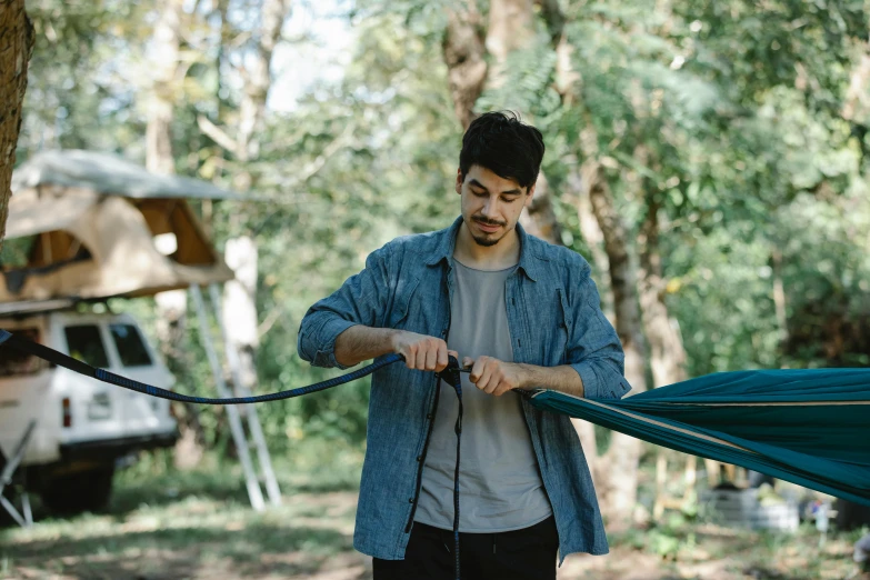 a man holding an umbrella in a wooded area, pexels contest winner, hanging rope, avatar image, glamping, nikolay georgiev