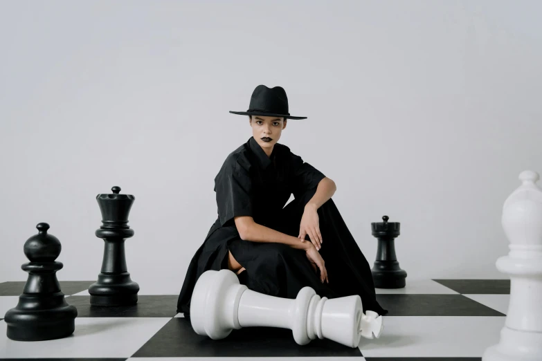 a woman sitting on top of a chess board, an album cover, unsplash contest winner, antipodeans, tall hat, nun fashion model, ignant, 15081959 21121991 01012000 4k