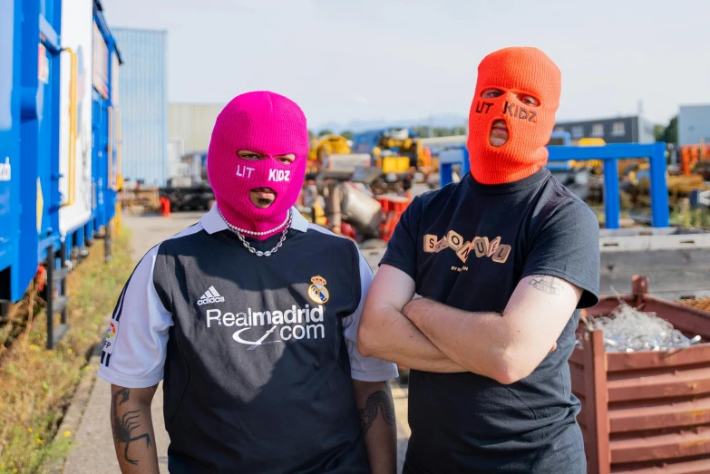 a couple of men standing next to each other, by karlkka, reddit, orange balaclava, pink face, in spain, bladee from drain gang