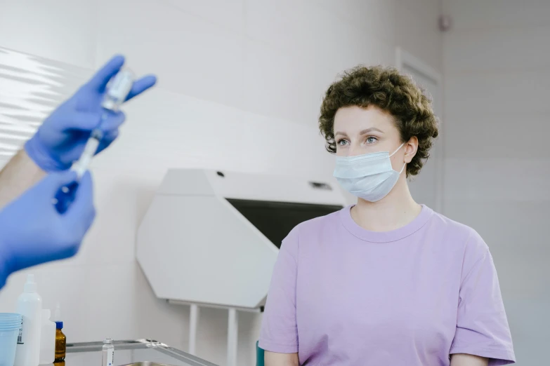 a woman in a purple shirt and blue gloves, pexels contest winner, doctors mirror, low quality photo, background image, dentist