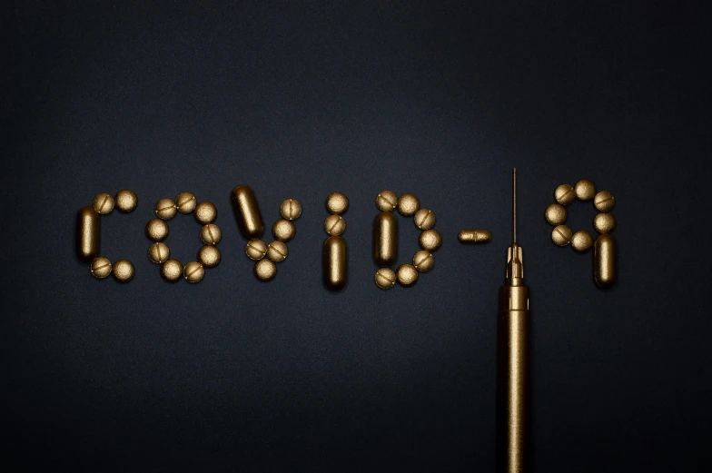 pills and a needle on a black background, by Adam Marczyński, trending on pexels, graffiti, sculpture made of gold, covid, typography, navy