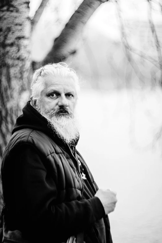 a man with a beard standing next to a tree, a black and white photo, unsplash, renaissance, a silver haired mad, slavoj zizek, фото девушка курит, matthew benedict