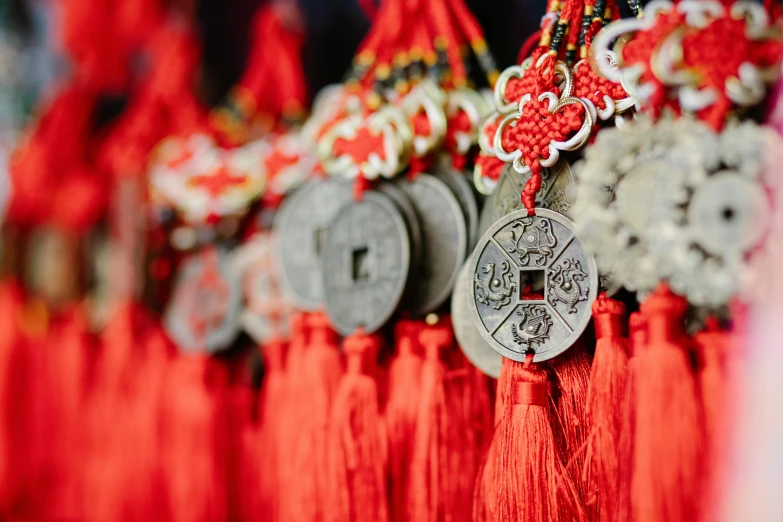 a row of red tassels hanging from a wall, inspired by Gong Xian, pexels contest winner, silver ornaments, 🦩🪐🐞👩🏻🦳, coins, intricate embroidery