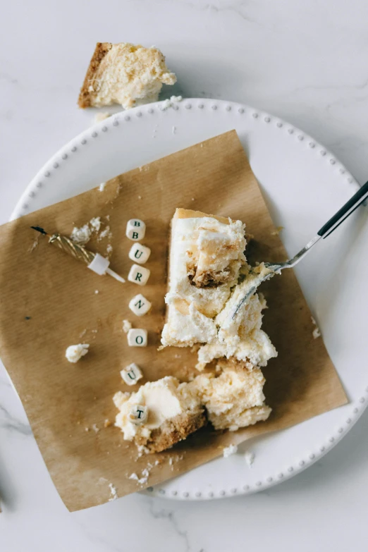 a white plate topped with a piece of cake, by Sara Saftleven, unsplash, baroque, cubes on table, parchment paper, tillamook cheese, thumbnail