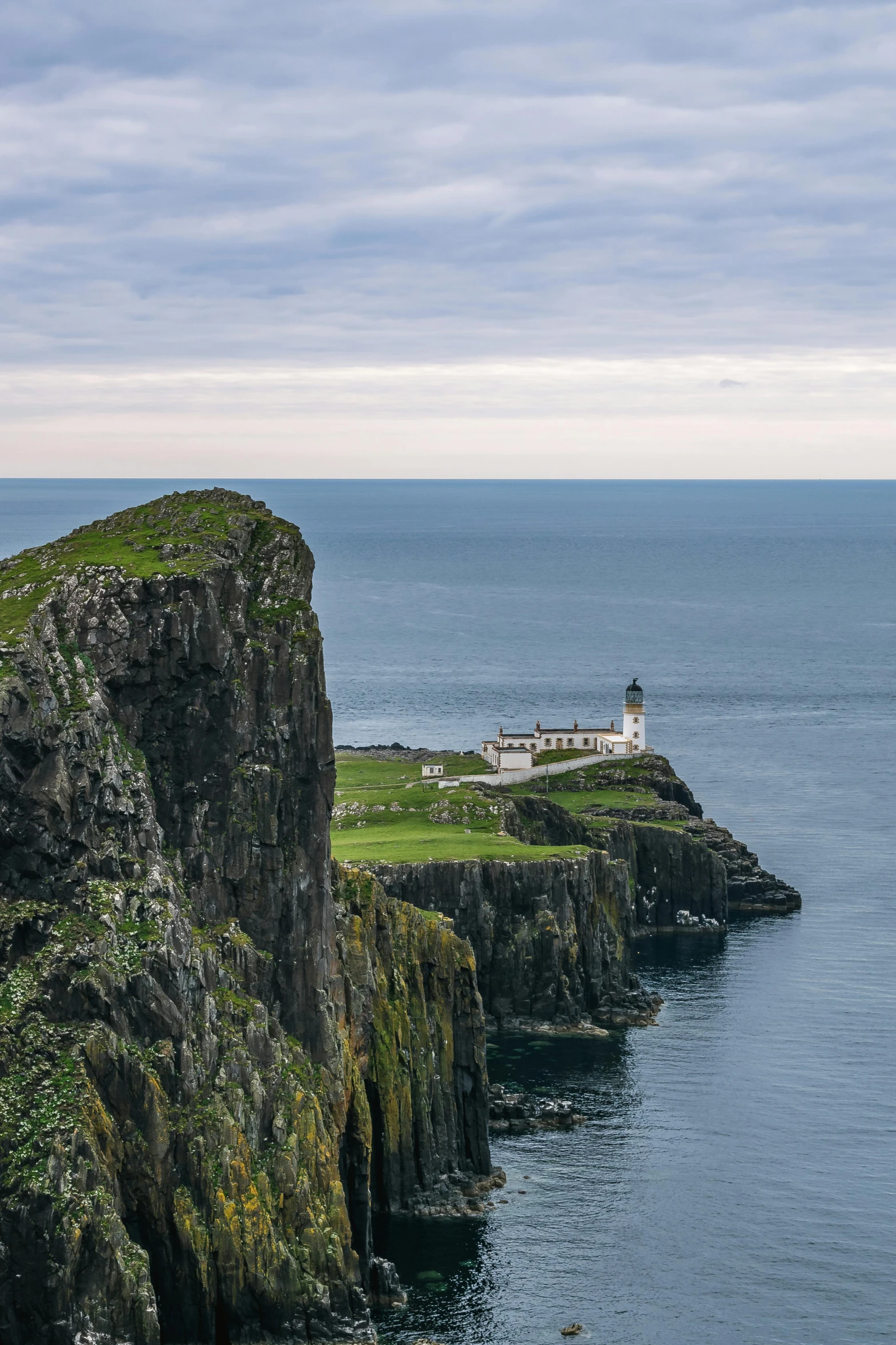 a lighthouse sitting on top of a cliff next to the ocean, skye meaker, in between a gorge, overlooking, stretch