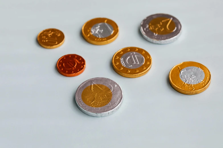 a bunch of coins sitting on top of a table, on a white table, high quality product image”, photography of kurzgesagt, miniatures