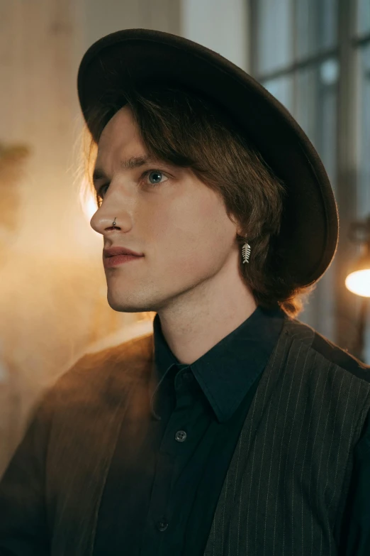 a close up of a person wearing a hat, a colorized photo, inspired by Johannes Mytens, delicate androgynous prince, standing in a dimly lit room, musician, side profile centered portrait