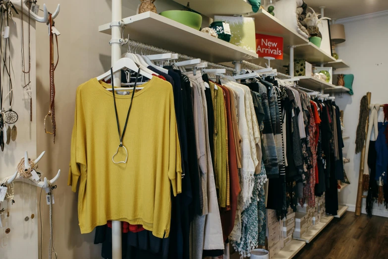 a rack of clothes in a clothing store, by Lee Loughridge, unsplash, hurufiyya, yellow and green scheme, presenting wares, caulfield, dolman