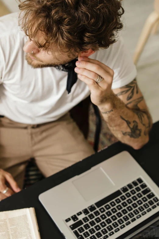 a man sitting in front of a laptop computer, trending on pexels, renaissance, tattooed, wearing a shirt with a tie, someone lost job, wearing black headphones