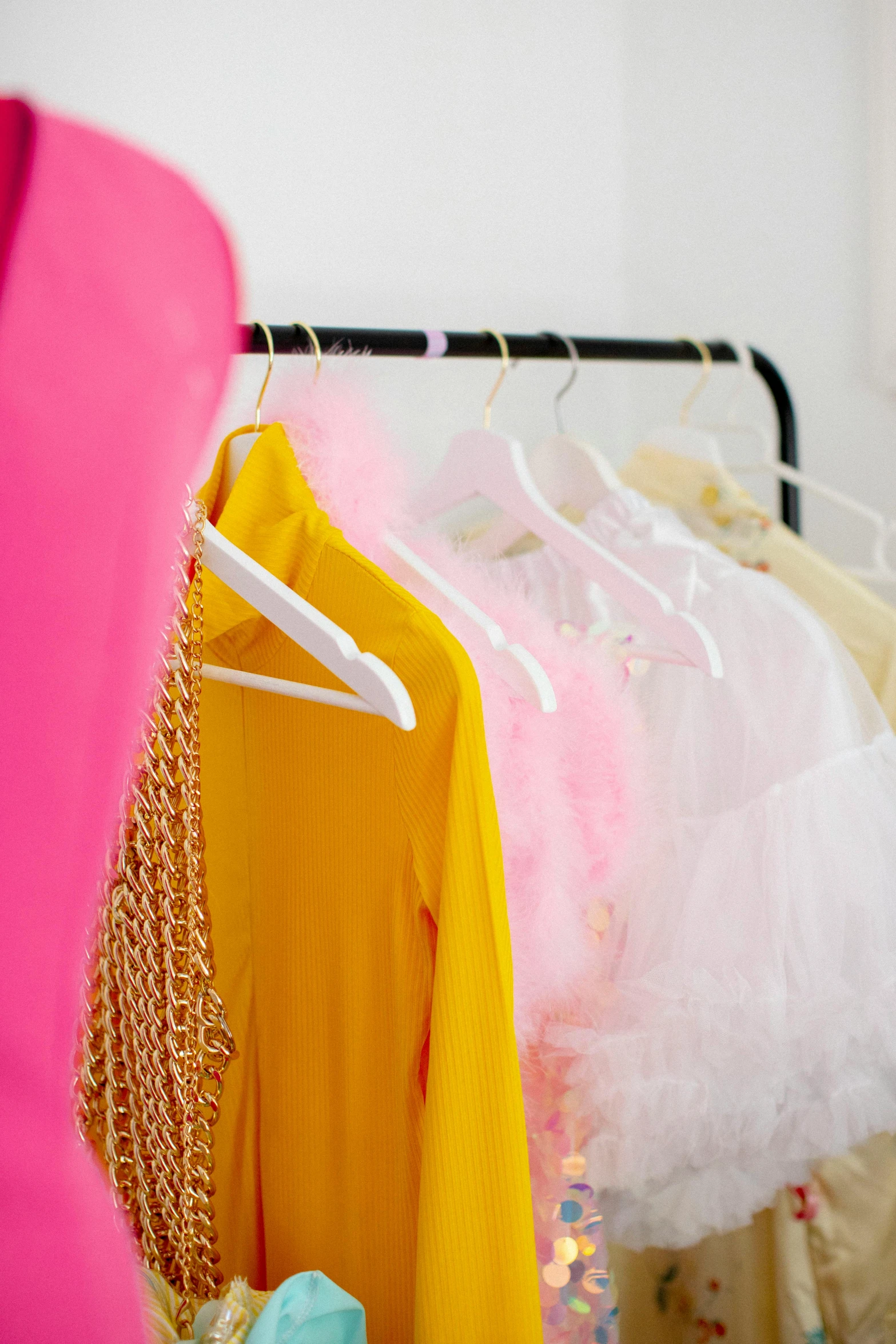 a woman standing in front of a rack of clothes, unsplash, rococo, pink and yellow, wearing a pink tutu, yellow robe, detailed product shot