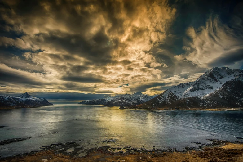 a large body of water surrounded by snow covered mountains, by Sebastian Spreng, pexels contest winner, romanticism, dramatic skies, coastal, conde nast traveler photo, norse inspired