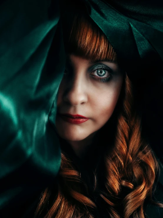 a close up of a woman with long red hair, an album cover, inspired by Cindy Sherman, unsplash contest winner, renaissance, wearing dark green robes, big eyes, unsplash photo contest winner, evil look