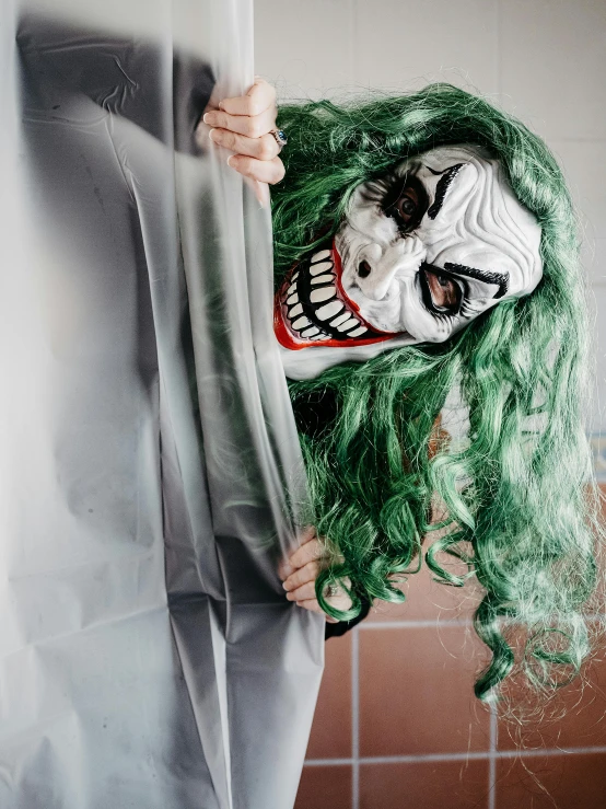 a close up of a person wearing a clown mask, green flowing hair, halloween ghost under a sheet, clenching, an intruder