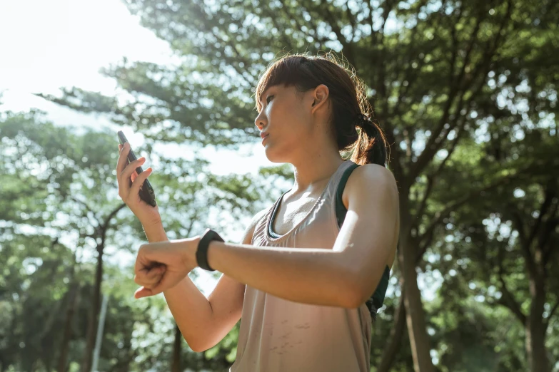 a woman holding a cell phone in her hand, pexels contest winner, working out in the field, avatar image, asian woman, heart rate