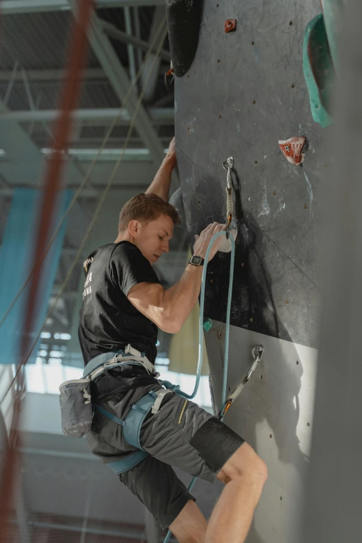 a man climbing up the side of a rock wall, in a gym, anton fadeev 8 k, shot on 1 5 0 mm, portrait of gigachad