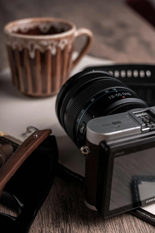 a camera sitting on top of a table next to a cup of coffee, a picture, detailed product image, detail shot, product shot, f / 2 0