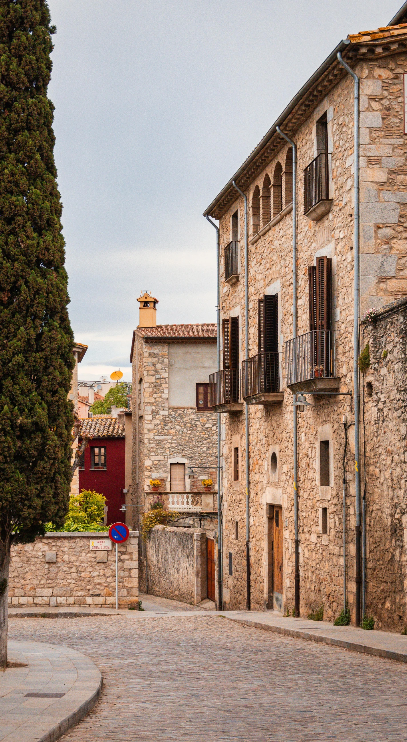 a red fire hydrant sitting on the side of a road, romanesque, crenellated balconies, ancient mediterranean village, beige, square