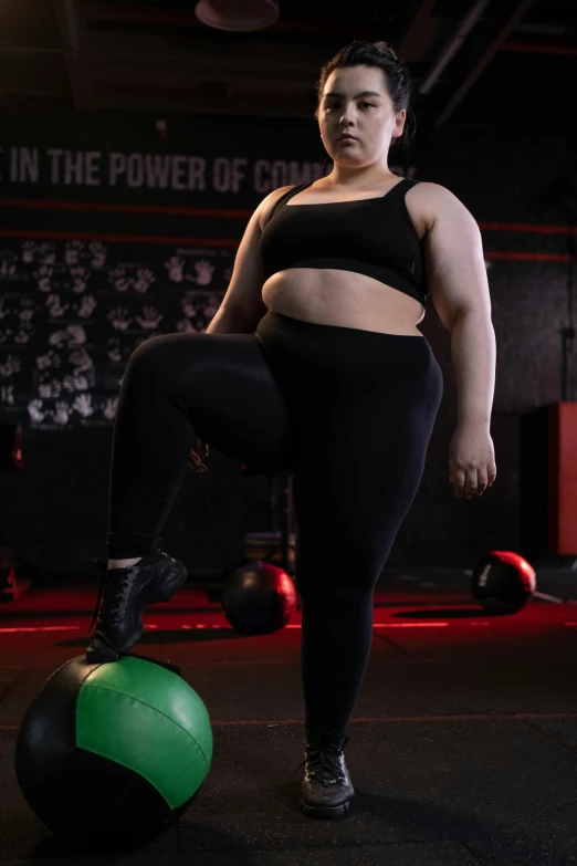 a woman standing on top of a ball in a gym, an album cover, trending on pexels, bbw, non binary model, large)}], fit pic