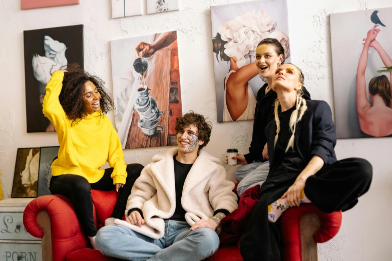 a group of people sitting on top of a red couch, a portrait, trending on pexels, arbeitsrat für kunst, apartment of an art student, smiling playfully, neoartcore and charlie bowater, relaxing on a couch