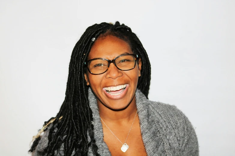 a woman with glasses smiling at the camera, alexis franklin, black on white background, slight overcast lighting, smiling playfully