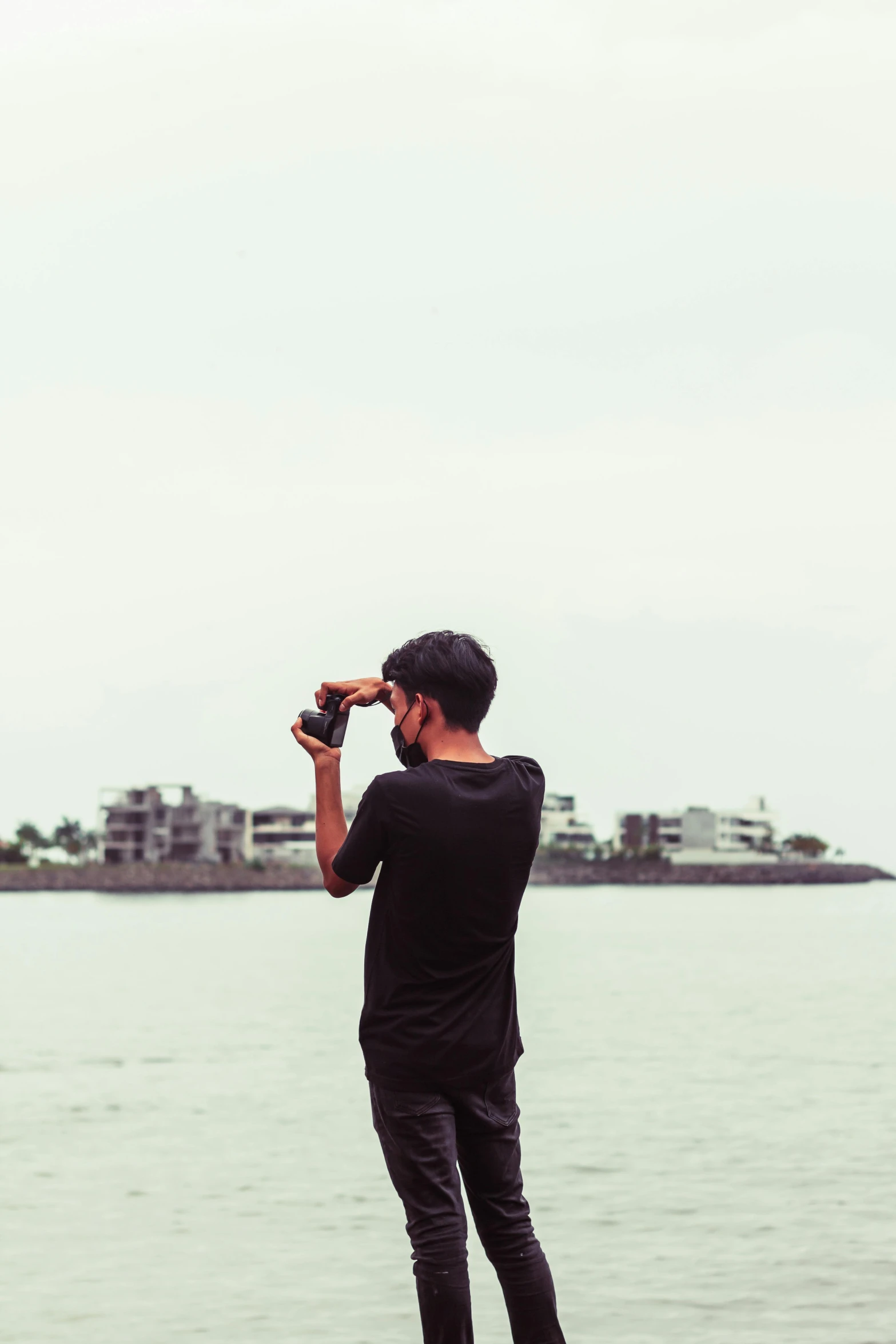 a man taking a picture of a body of water, shot on sony a 7, leica s photograph, haze over the shoulder shot, half - body shot