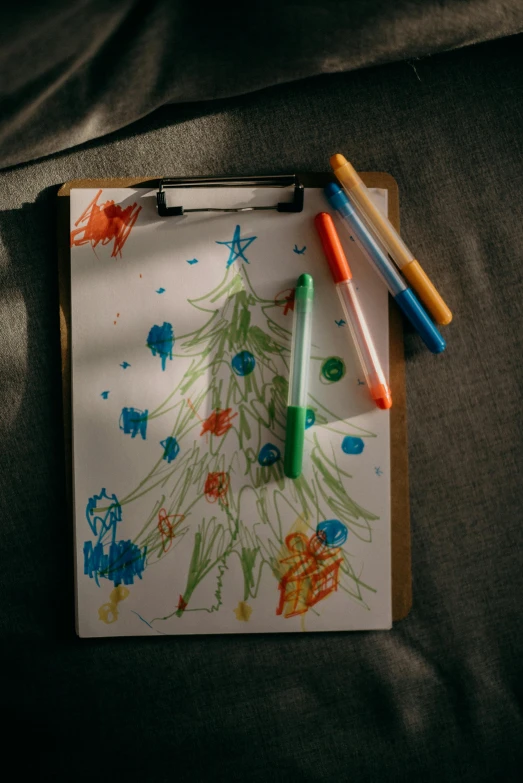 a clipboard with a drawing of a christmas tree on it, a child's drawing, pexels, crayon art, thumbnail, cinematic shot, illustratio