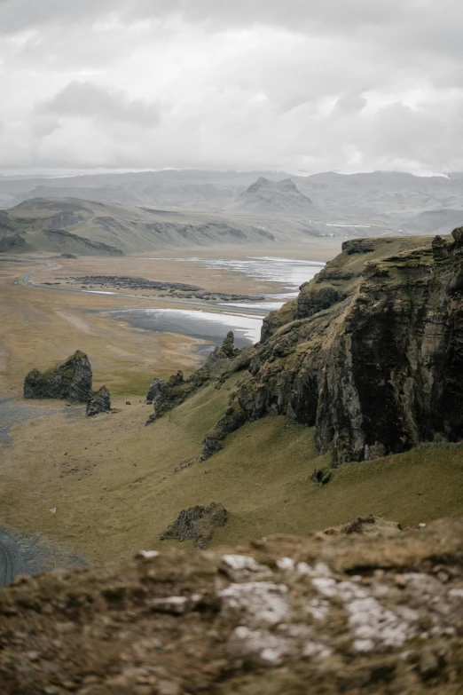 a man standing on top of a mountain next to a body of water, by Þórarinn B. Þorláksson, unsplash contest winner, renaissance, distant town in valley and hills, erosion algorithm landscape, an expansive grassy plain, seen from afar