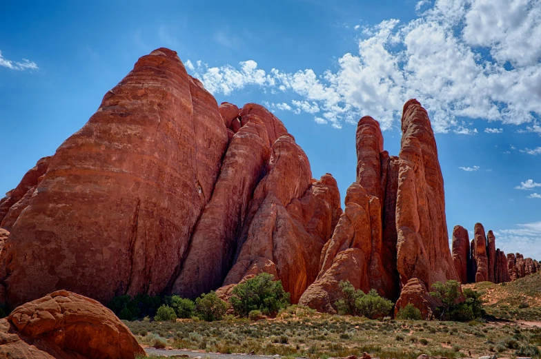 a group of rocks sitting in the middle of a desert, by Peter Churcher, pexels contest winner, art nouveau, tall arches, reddish, colorado, two giant towers