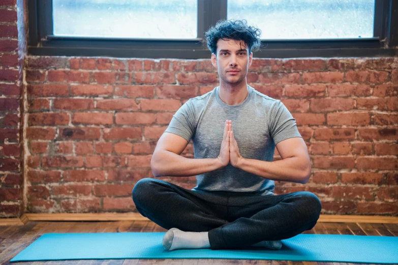 a man sitting on a yoga mat in front of a window, pexels contest winner, confident stance, lachlan bailey, thumbnail, with a spine crown