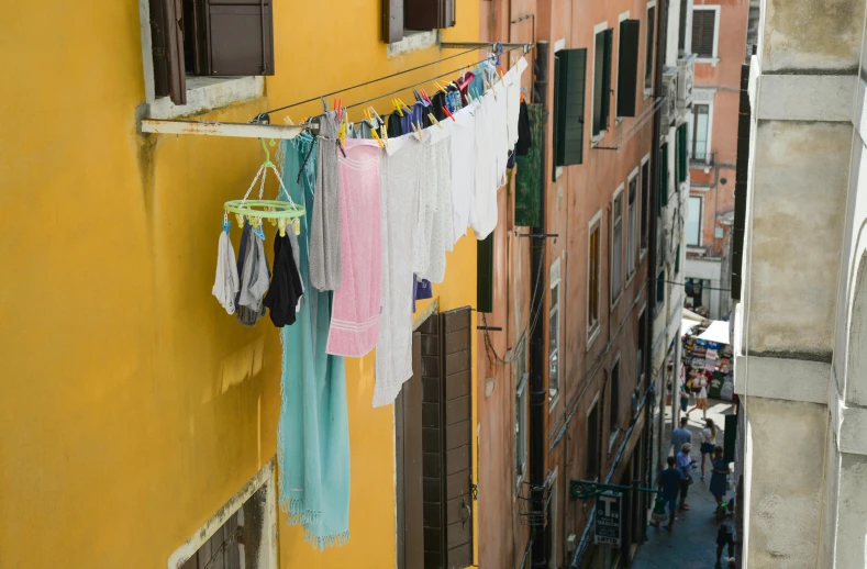 clothes hanging out to dry on a clothes line, by Giorgio De Vincenzi, pexels contest winner, renaissance, brightly colored buildings, slide show, yellow awning, sea - green and white clothes