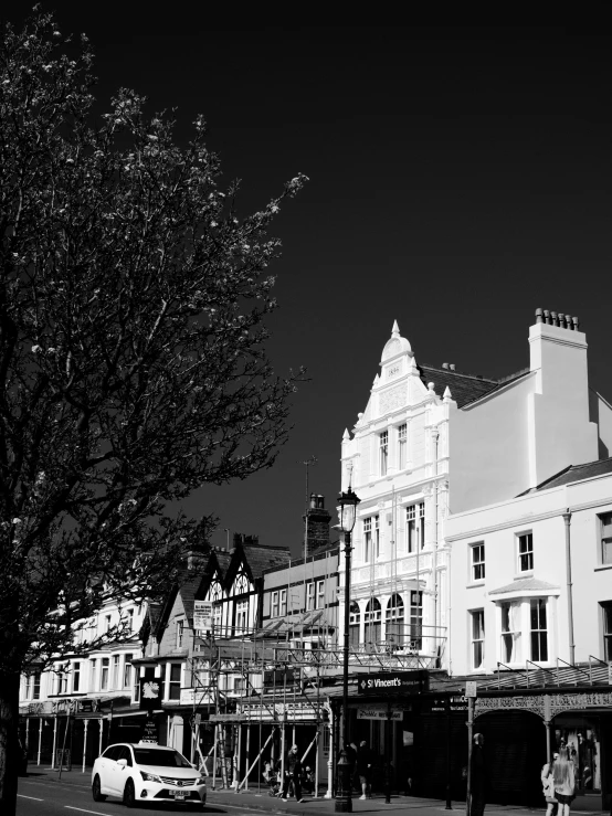 a black and white photo of a city street, by Kev Walker, seaside victorian building, detailed medium format photo, trees around, high contrast!