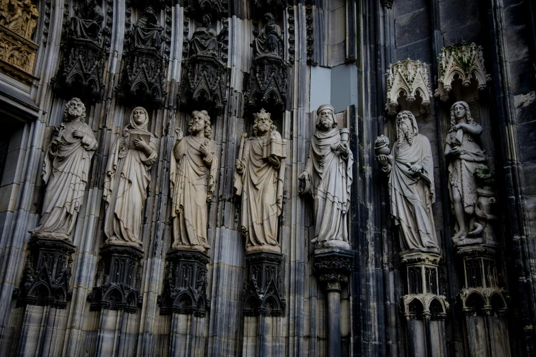 a group of statues on the side of a building, by Tobias Stimmer, pexels contest winner, gothic art, cathedral!!!!!, stones, cream, dark and intricate