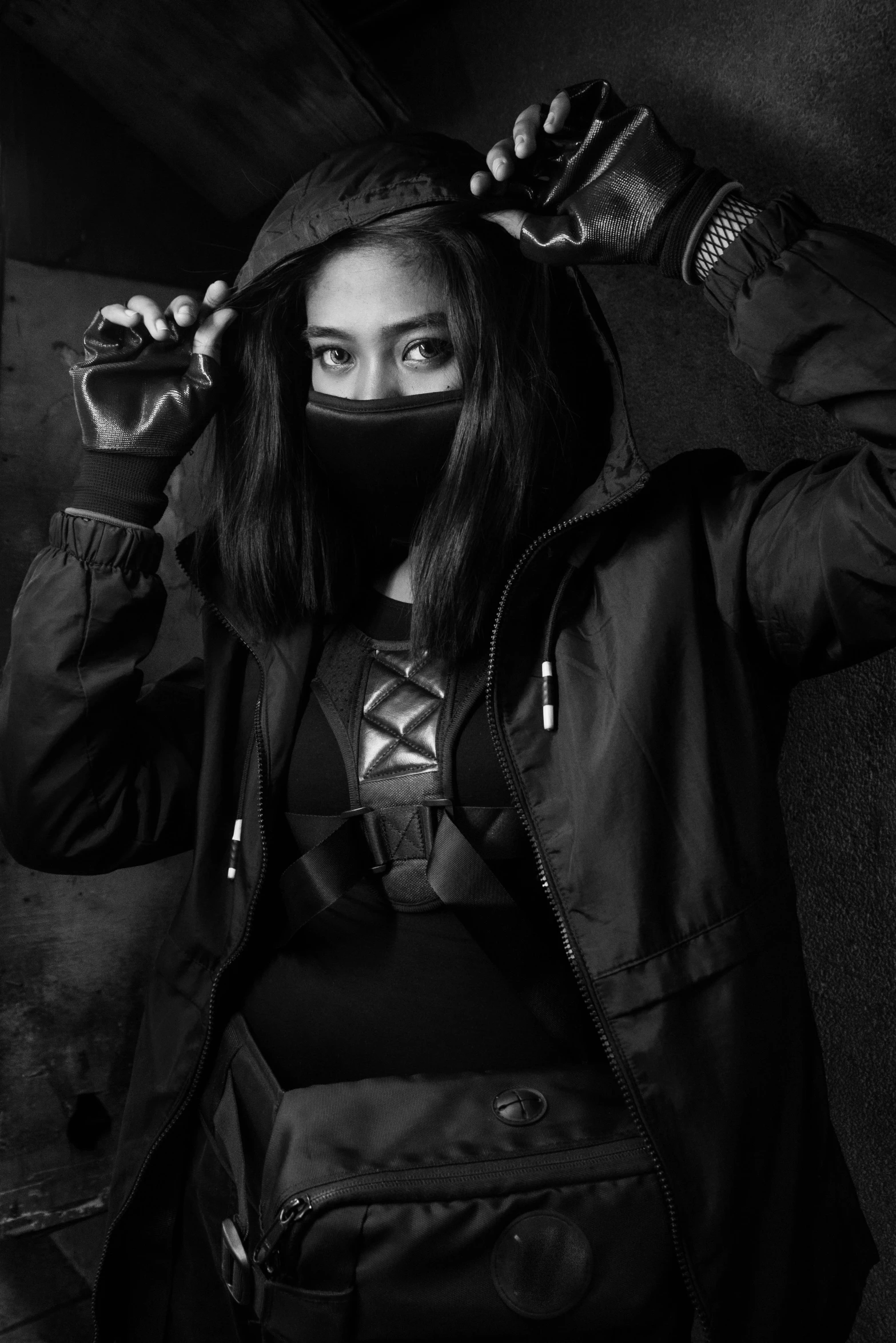 a black and white photo of a woman in a hoodie, a character portrait, inspired by Oka Yasutomo, wearing techwear and armor, gamora, taken in 2 0 2 0, black mask