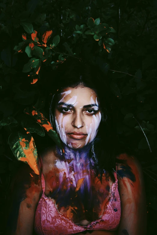 a woman with paint all over her face, an album cover, inspired by Elsa Bleda, trending on pexels, clothed in vines, olive skin, violet myers, splash of color