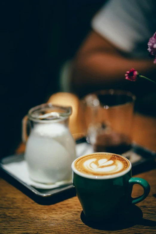 a cup of coffee sitting on top of a wooden table, by Niko Henrichon, trending on unsplash, aussie baristas, mid night, next to a cup, milk and mocha style