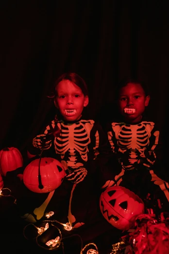 a group of children dressed up in halloween costumes, an album cover, by Gwen Barnard, pexels, vanitas, 256435456k film, twins, black light, snacks