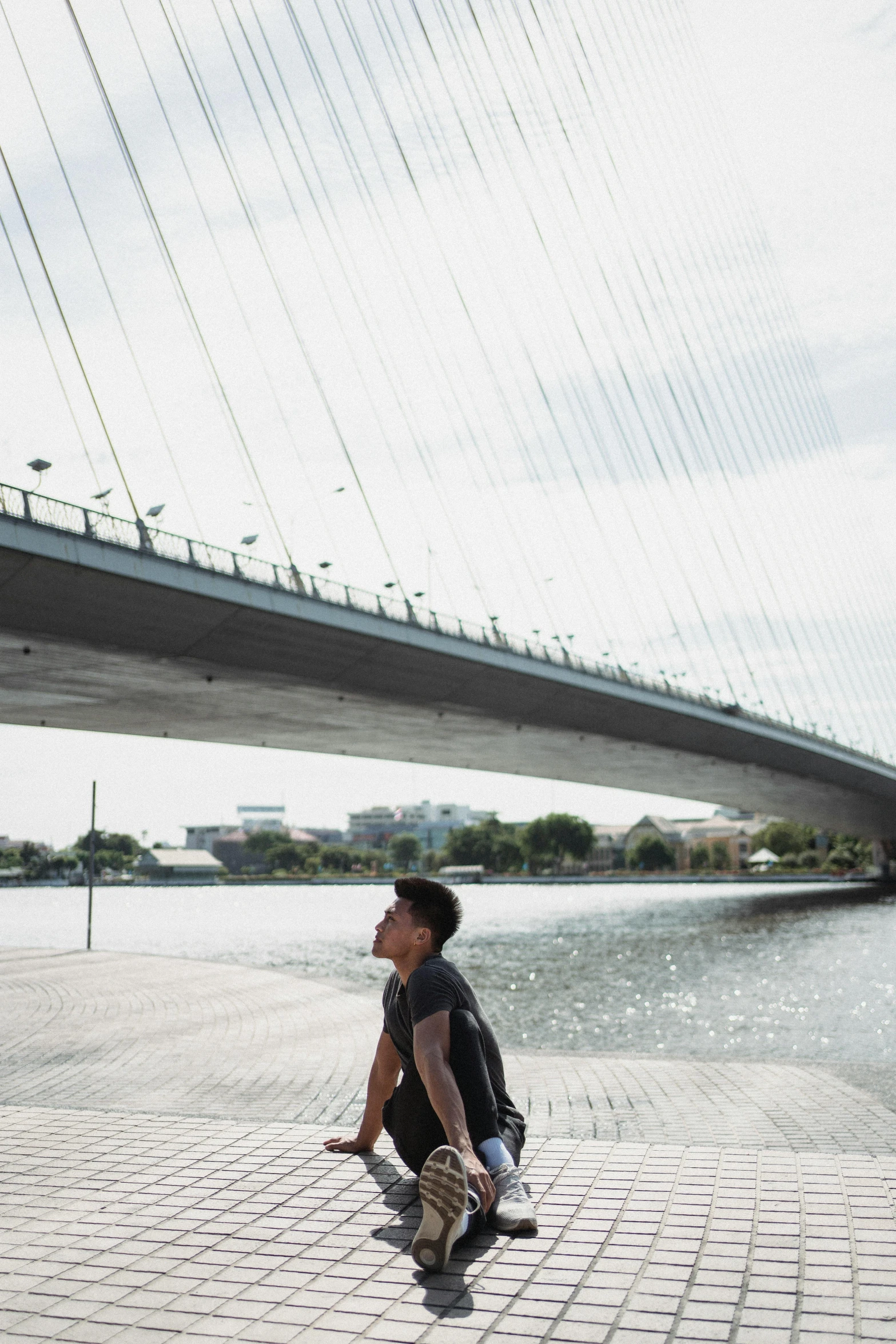 a man on a skateboard in front of a bridge, inspired by Zha Shibiao, trending on unsplash, bangkok, standing next to water, portrait of tall, calatrava